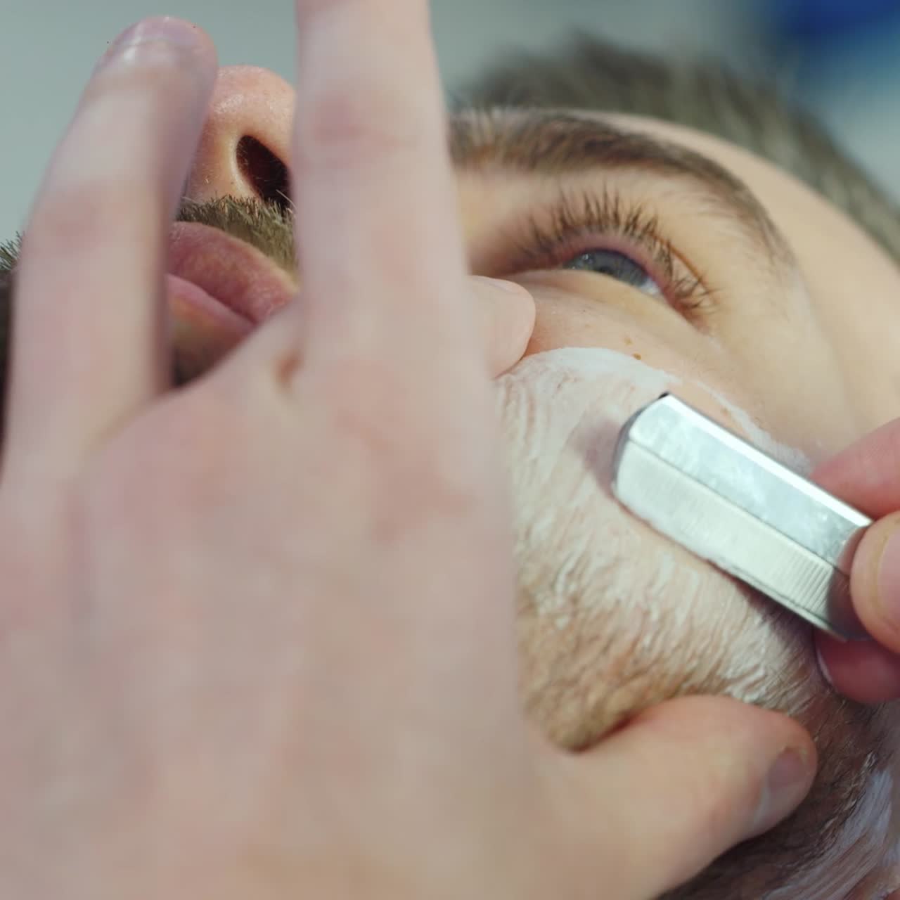 수염을 자르기 위해 면도날을 사용하는 이발사 01