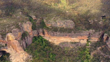 antena: movimiento de inclinación hacia arriba sobre la escarpa de la montaña para revelar el icónico edificio hidromajestuoso en las montañas azules, nsw, australia