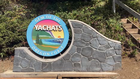 a stone and wood sign promoting yachats, oregon