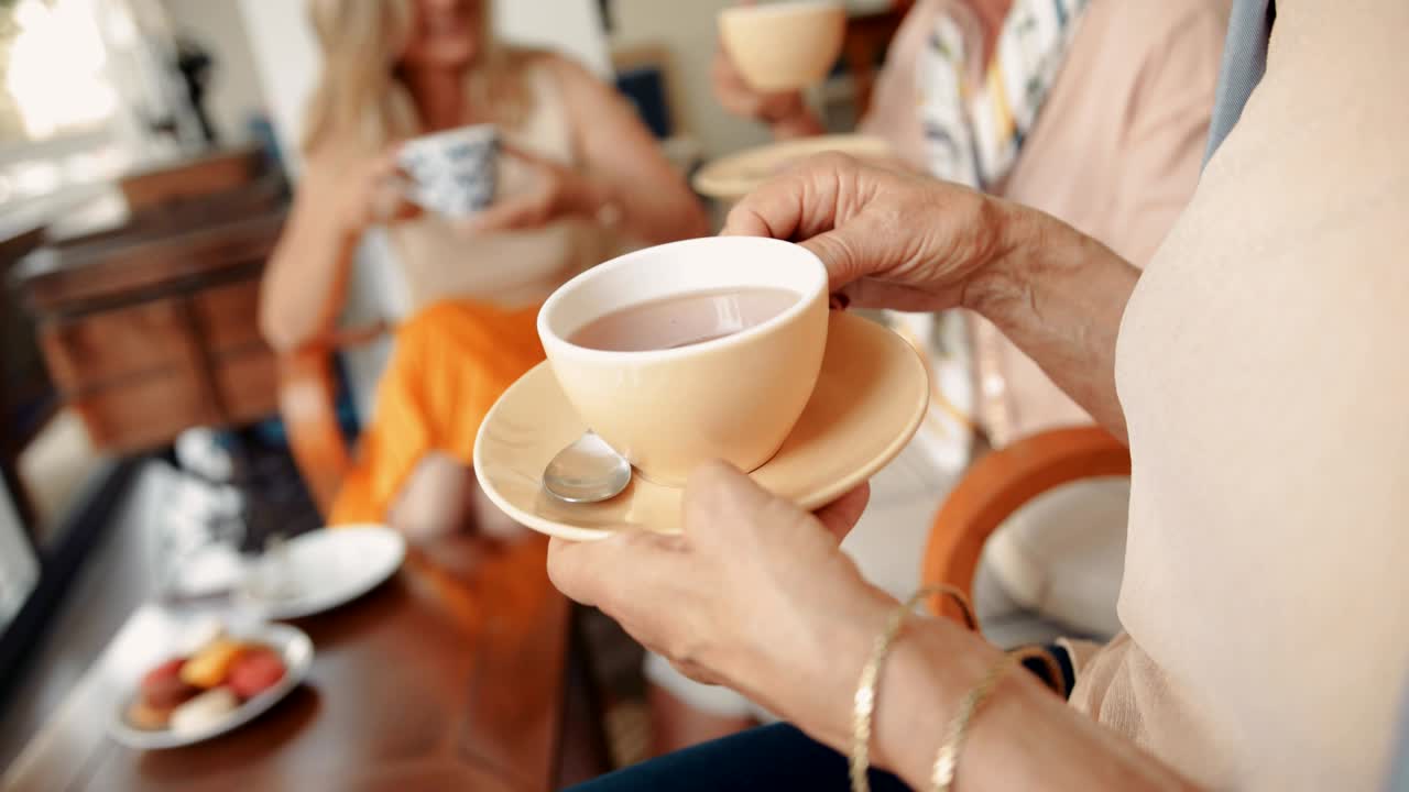 성숙한 여성들이 집에서 함께 커피를 마시고 있습니다.