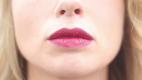 un primerísimo plano de los labios de una mujer atractiva curvándose lentamente y sonriendo