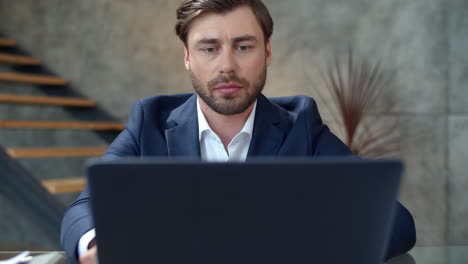 Focused-businessman-working-on-laptop-in-office