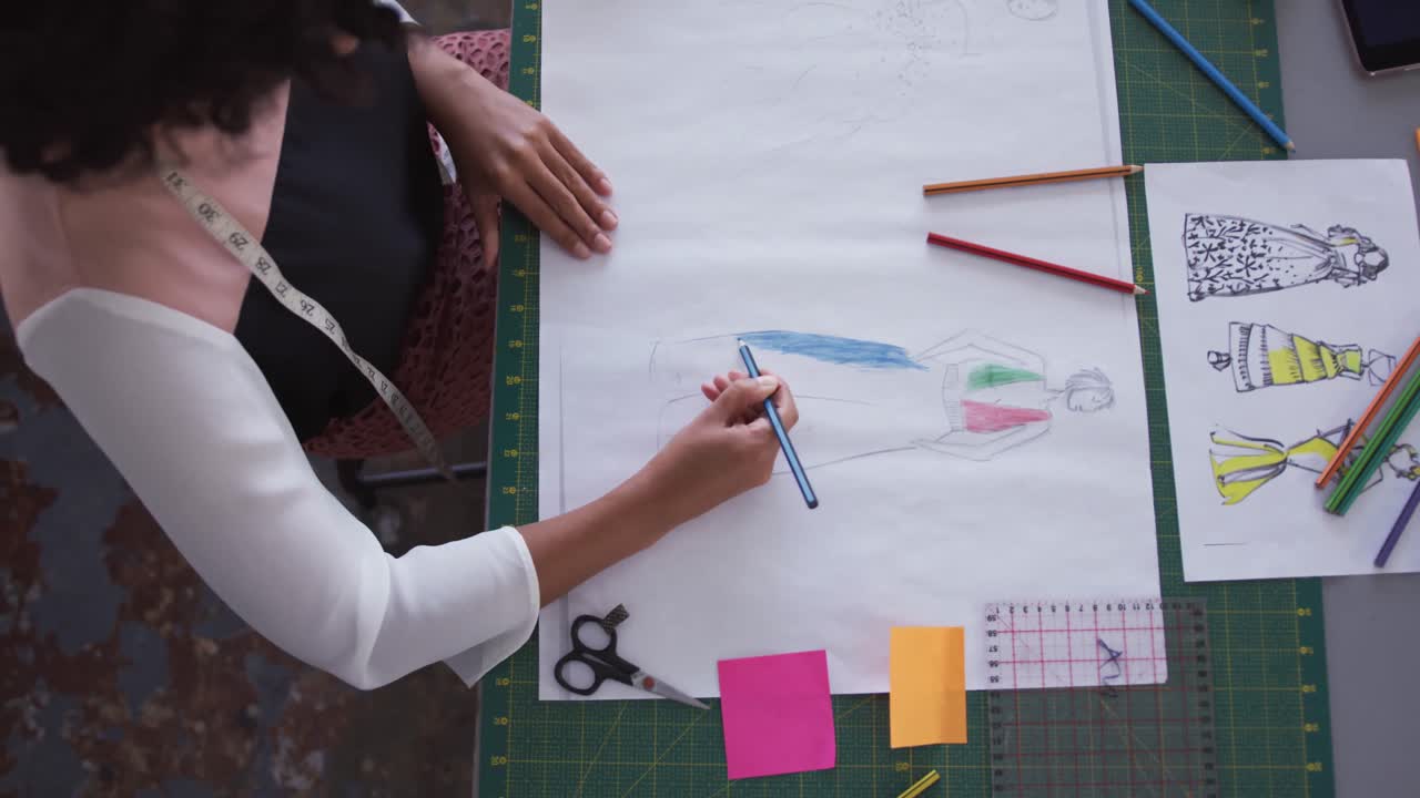 mujer de raza mixta dibujando en la oficina de moda