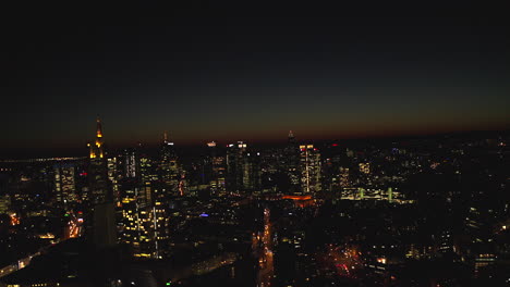 Establishing-Shot-of-Frankfurt-am-Main,-Germany-big-city-Skyline-and-Skyscraper-Buildings-at-Night-with-beautiful-City-lights,-Aerial-Wide-angle-view