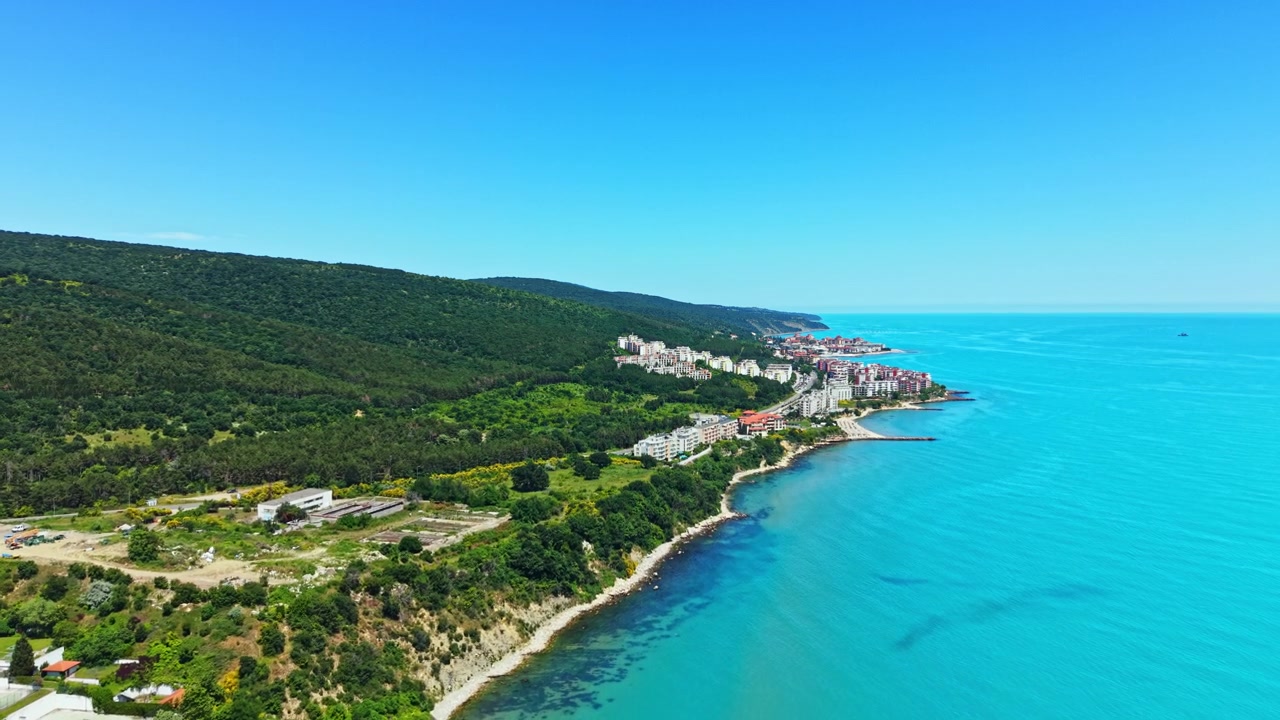 Veduta della costa con edifici, alberi e acqua in una zona costiera in una giornata limpida