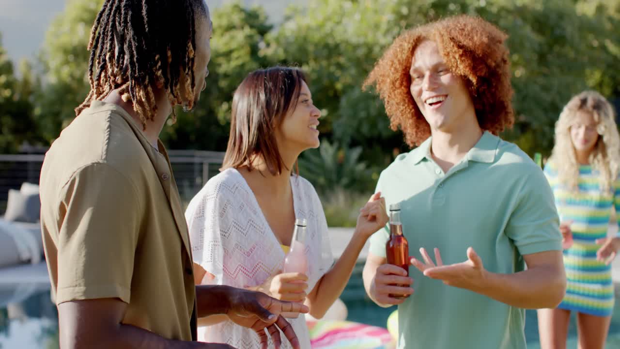 amigos diversos felices con bebidas hablando en el sol en la fiesta de la piscina, cámara lenta