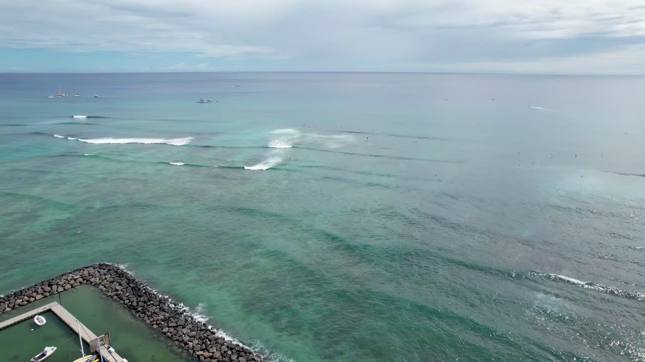 방파제와 배경 바위 더미 해변에서 파도와 하와이 항구