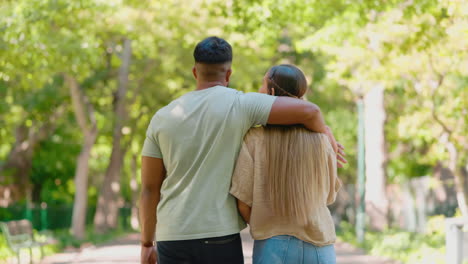 la espalda de una pareja caminando con el brazo alrededor en el parque