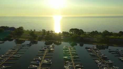 Aerial,-Tracking-Shot-of-Cars-Driving-on-Highway-with-Harbor-in-Foreground-and-Water-in-Background