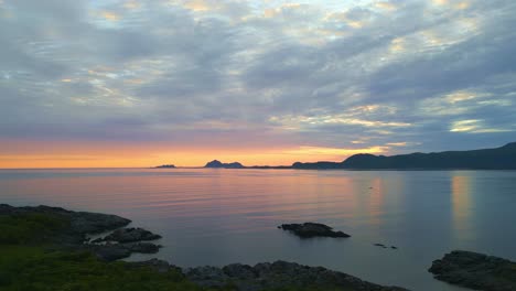 Lofoten-island-sea-flight,-drone-flight-over-arctic-water-during-sunset-on-the-lofoten-islands