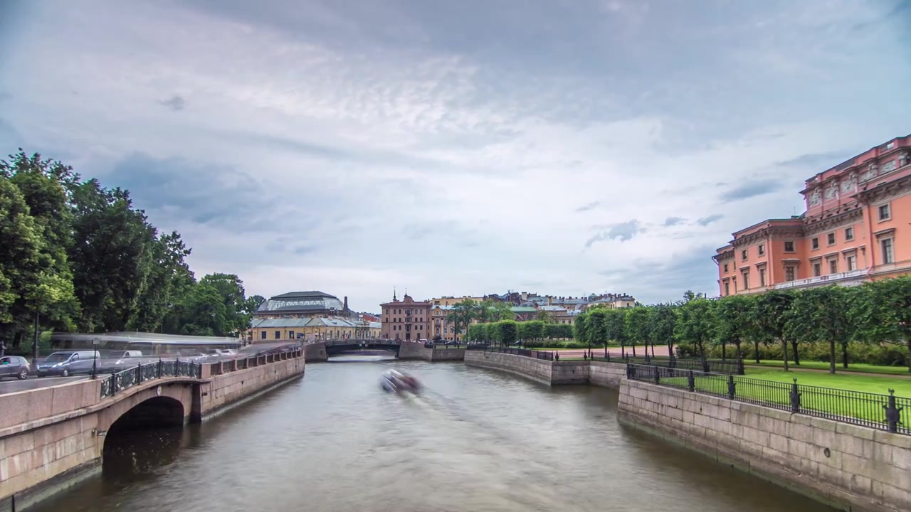 Vista dell'argine del fiume Mojka e del Castello Mikhailovsky in timelapse hyperlapse dal ponte. Nuvole scure nel cielo. San Pietroburgo. Russia