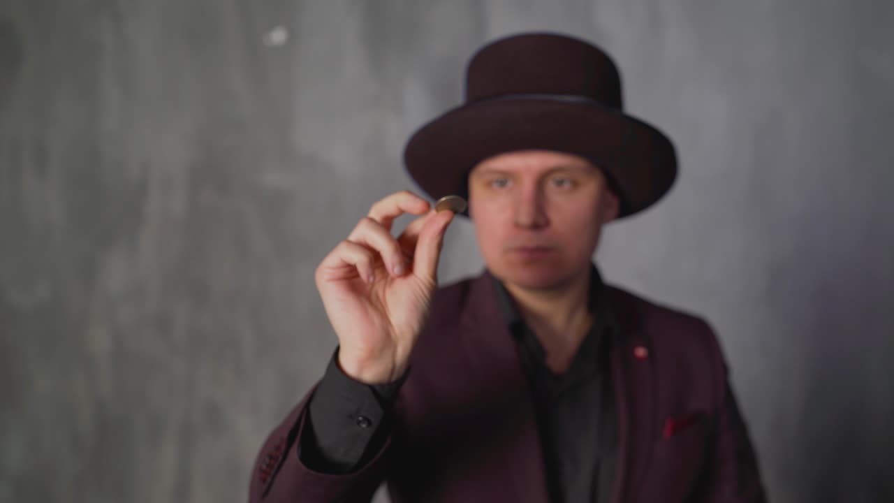 портрет волшебника, кусающего монету, стоящего на заднем плане. концепция инфляции. волшебник кусает монету