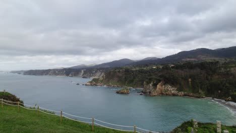 Slow-reveal-dolly-shot-from-a-horreo-in-a-cliff-by-the-sea,-typical-granary-from-Asturias-the-north-of-the-Iberian-Peninsula,-traditional-farm-building