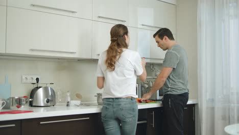 una pareja discutiendo teniendo un conflicto en la cocina de la casa.