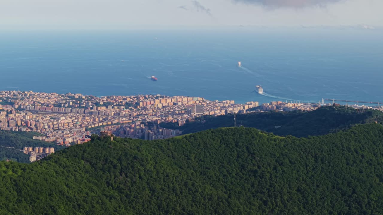 Italy's coastline with city buildings, green hills, and ocean, aerial view