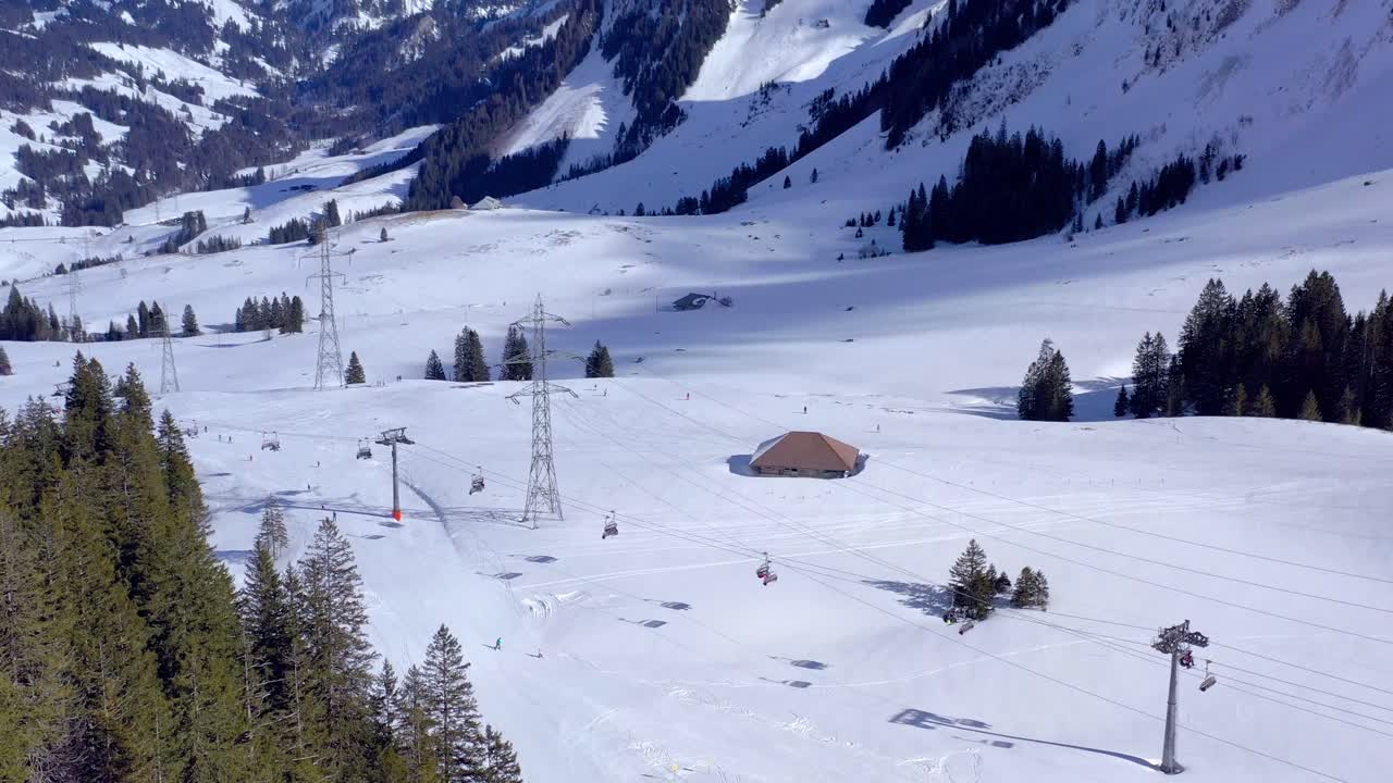 toma aérea bajo el brienzer rothorn en la estación de esquí de sörenberg con nieve en invierno - el mejor destino para familias en la biosfera de la unesco entlebuch | suiza por dron