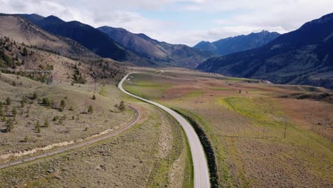 drone revealing a car driving through mountain highway