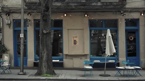 fotografía estática de la terraza vacía exterior de un bar con un diseño de tema azul y blanco en un día nublado