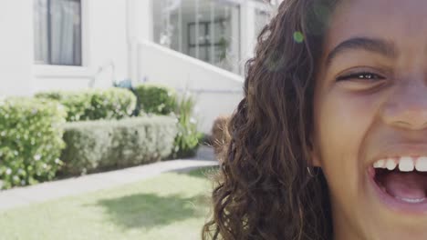 portrait of happy african american girl smiling in garden with copy space, slow motion