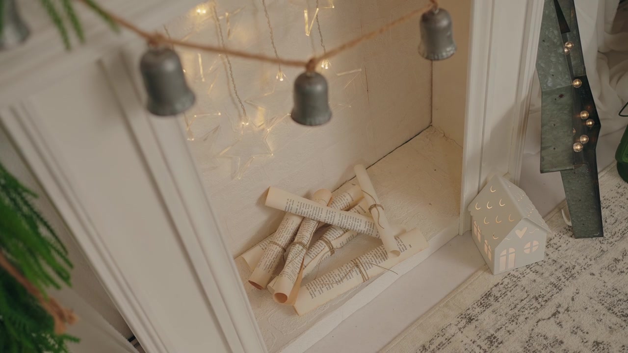 Ghirlanda di campane natalizie con pagine vintage arrotolate e decorazioni festive in un'ambientazione accogliente.