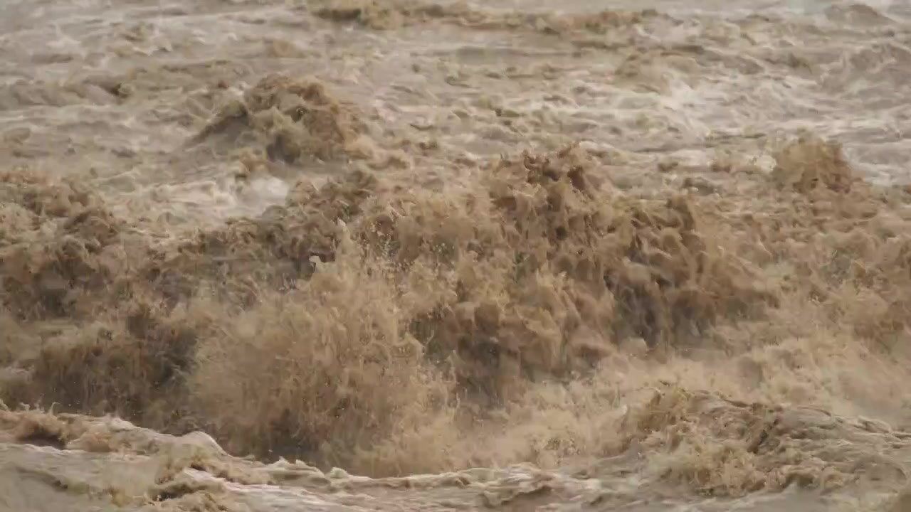 Acqua impetuosa e torbida del fiume che scorre rapidamente