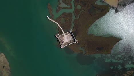 ancient castle sinking in a shallow lagoon tide in albania - a visual metaphor for the impact of global warming, eerie consequences