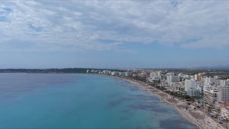 Mallorca:-Vista-Aérea-De-La-Ciudad-Turística-De-Son-Servera-En-La-Isla-De-Mallorca,-España,-Europa-|-Multitud-De-Playa-Sigue