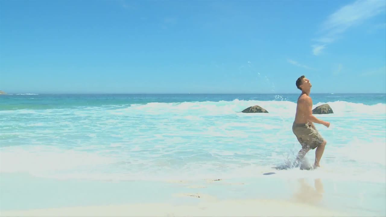 해변에서 축구공을 들고 있는 남자