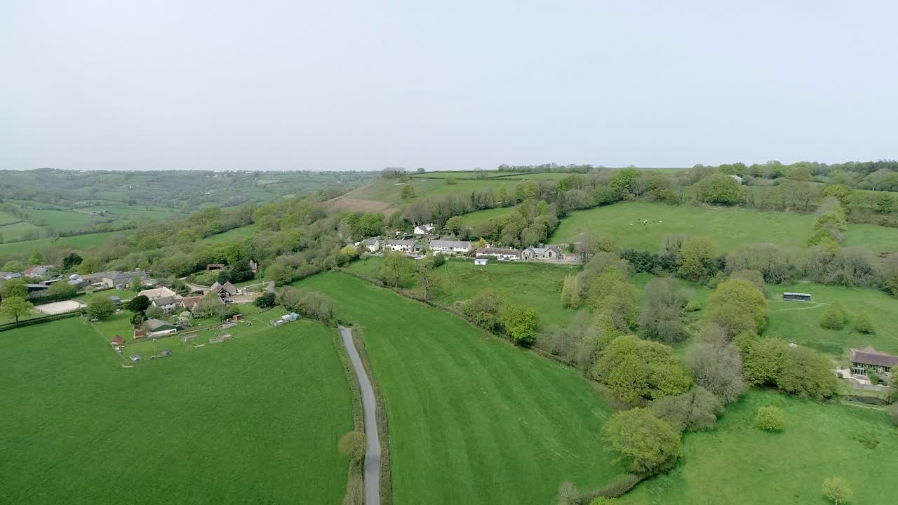 Aerial moving forwards towards beautiful quaint english country village in the heart of Devon