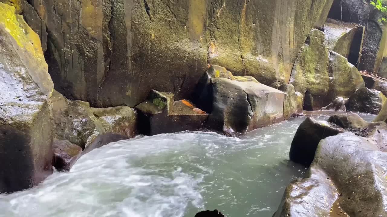 Goa Rang Reng Waterfall in Bali with a Close up of Large Rocks and River, Indonesia.