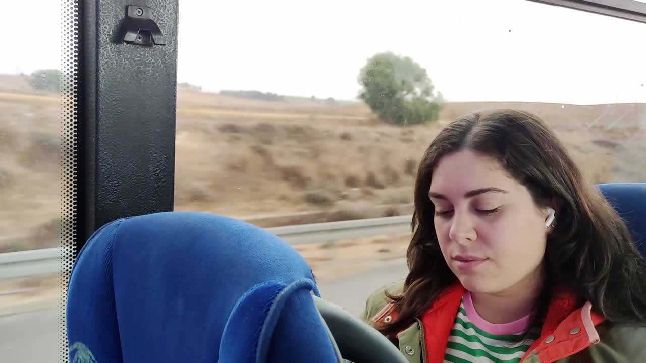 Tourist listening to music with earbuds while traveling by bus in the winter