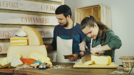 Teamwork---Man-And-Woman-Working-Together-At-The-Counter-Of-The-Cheese-Shop-They-Are-In-A-Good-Mood-