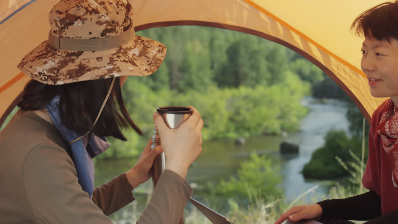 Asian Tourists Using Laptop and Drinking Tea at Campsite