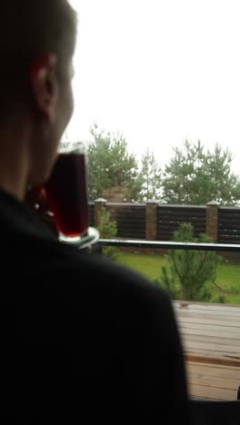 woman drinking tea and looking out the window on a rainy day