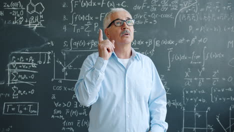 teacher pondering in front of blackboard filled with equations