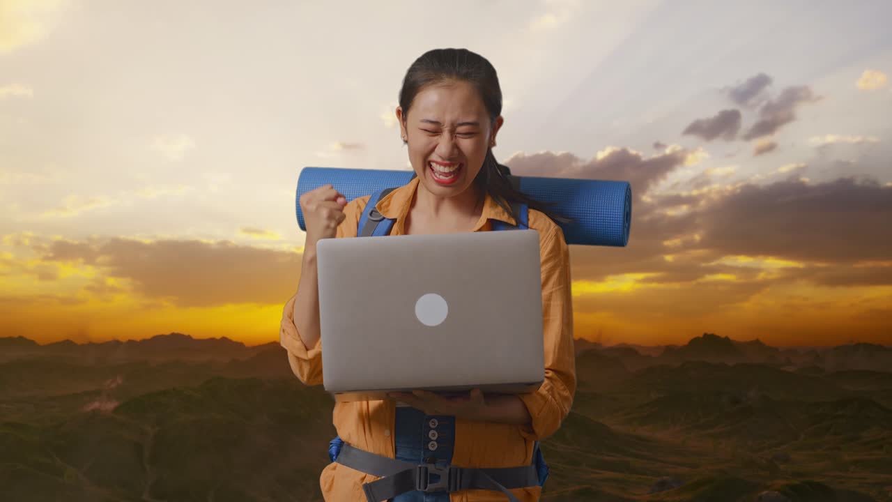 Excited Woman with Laptop on a Mountain Sunrise