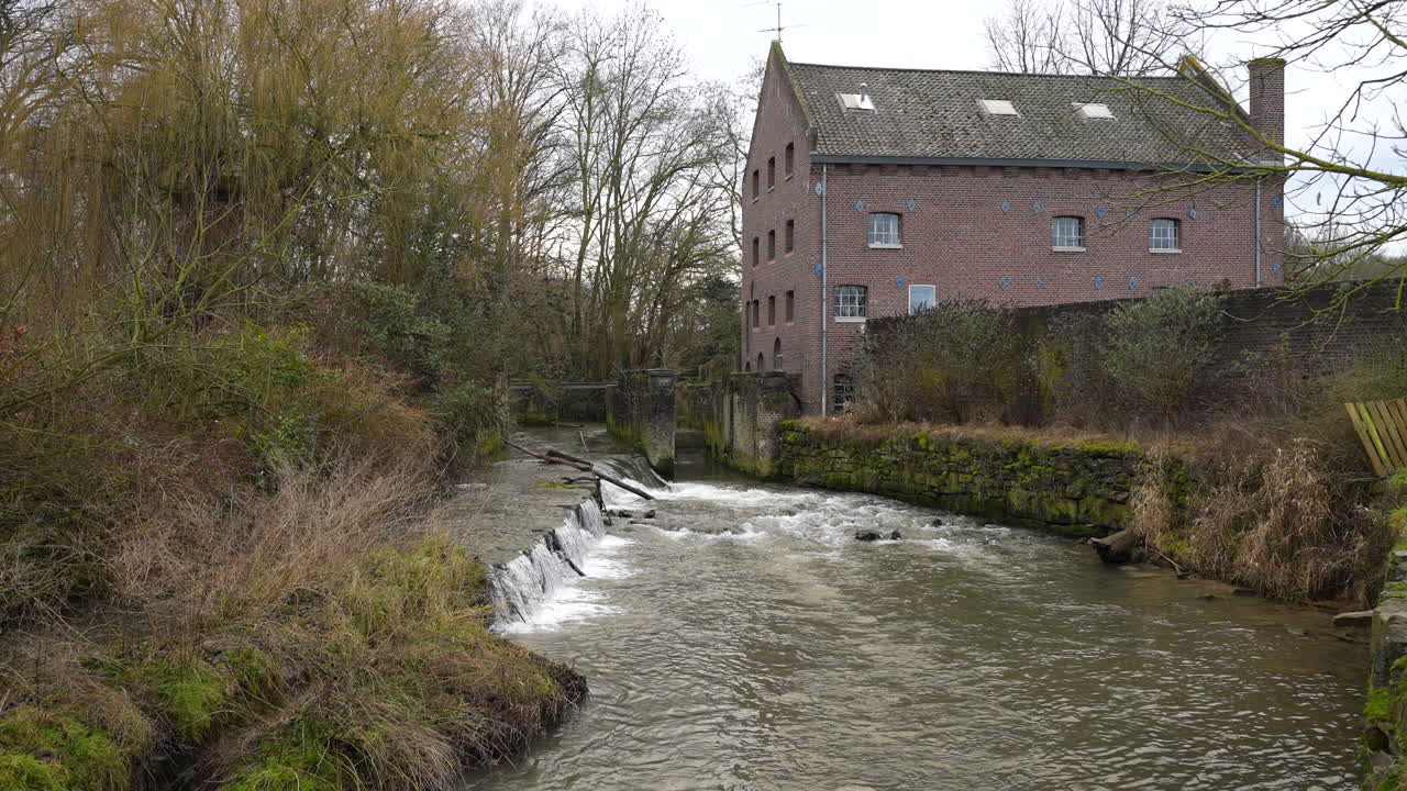 Alte Wassermühle aus roten Ziegeln in Belgien, aus der Hand gefilmt