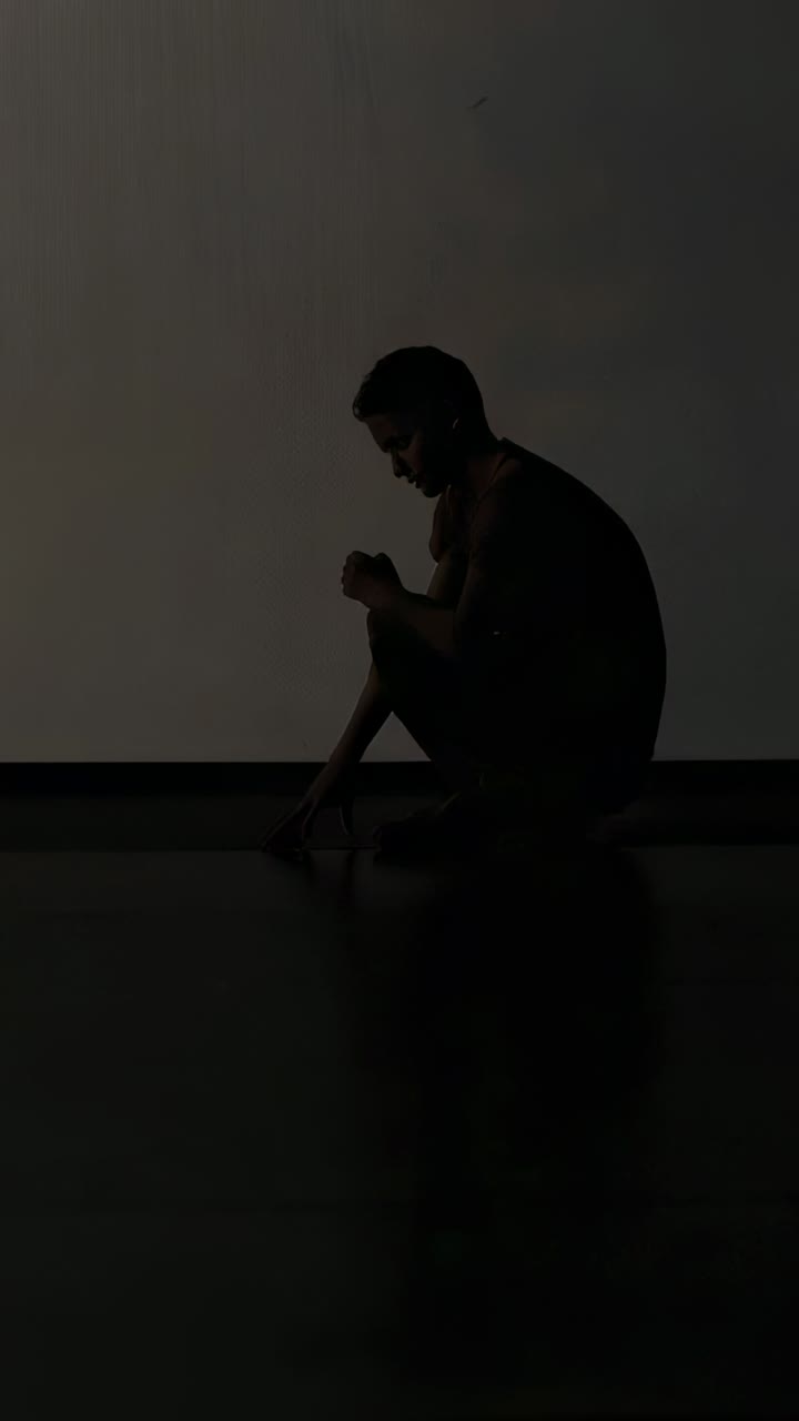 Video verticale: spostamento in avanti, uomo che si china, tocca il pavimento e si stabilizza vicino alla sporgenza in studio
