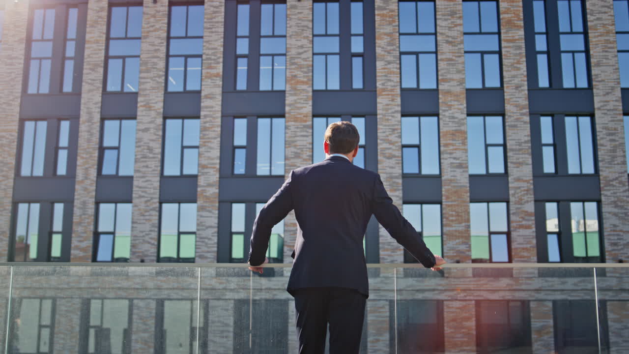Business man watching architecture sunny city back view. Entrepreneur standing