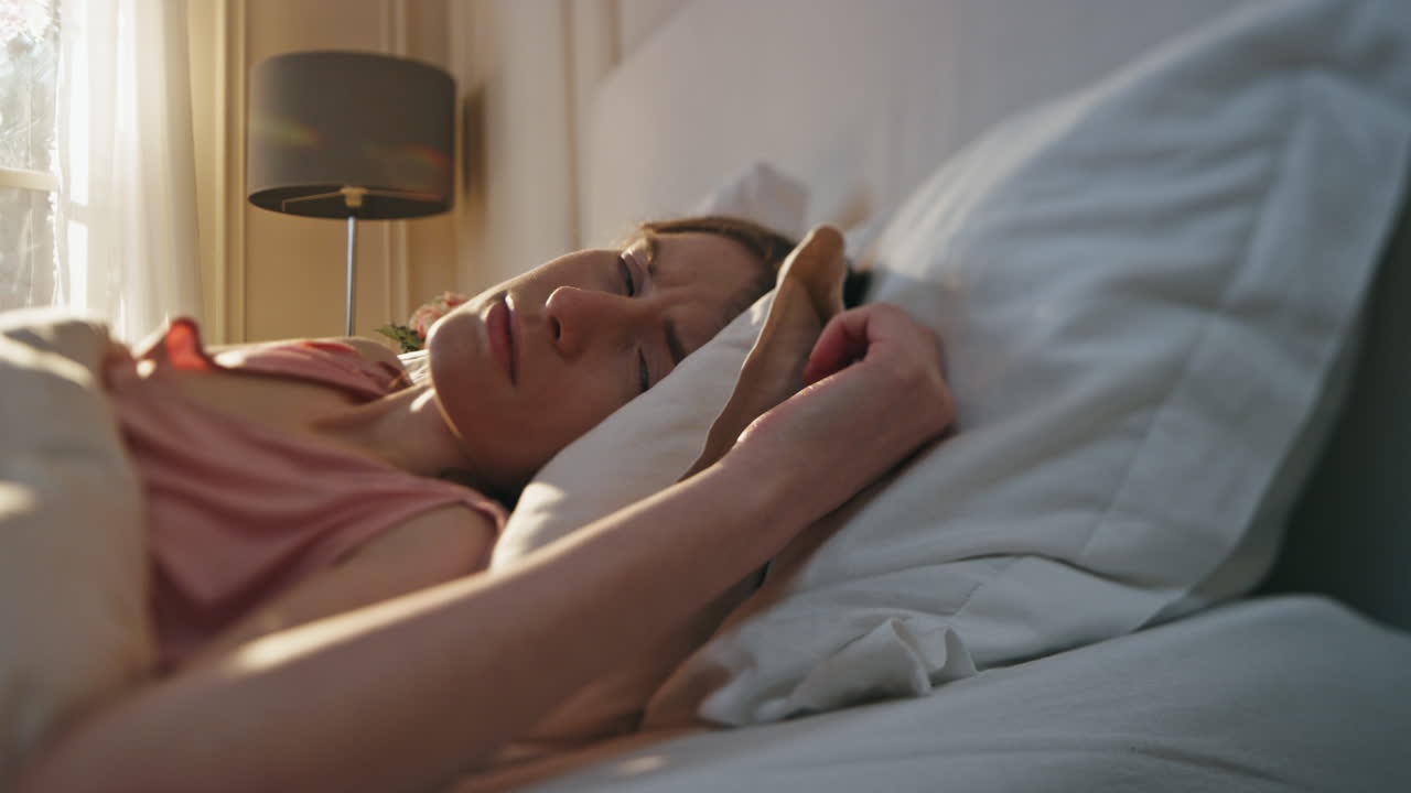 en primer plano una chica infeliz despertando temprano en la mañana. una mujer molesta apagando la alarma