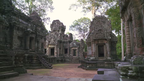 wide static of ancient stone temples in angkor with worn steps and detailed relief carvings