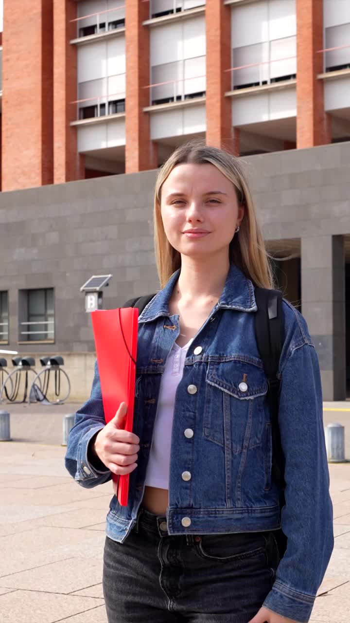 Studente con giacca di jeans e cartellina rossa
