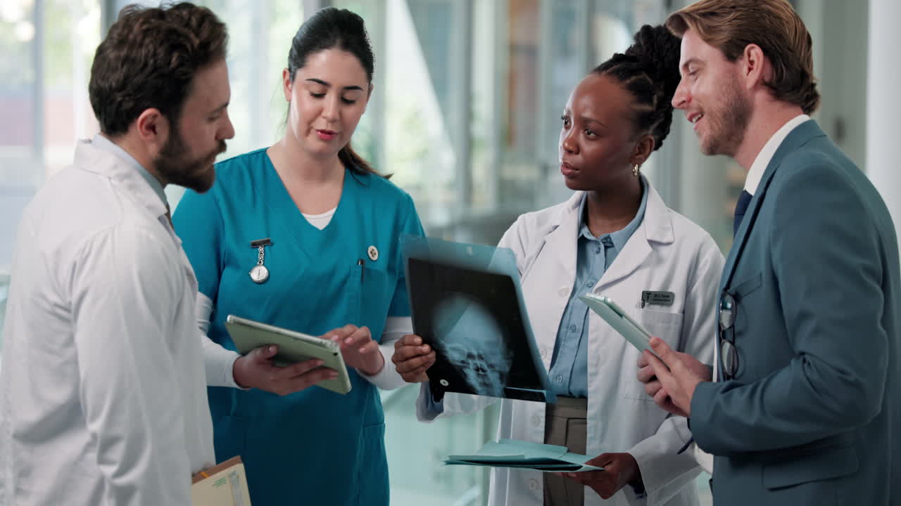 Medical Team Discussing Patient X-Ray and Data on Tablets