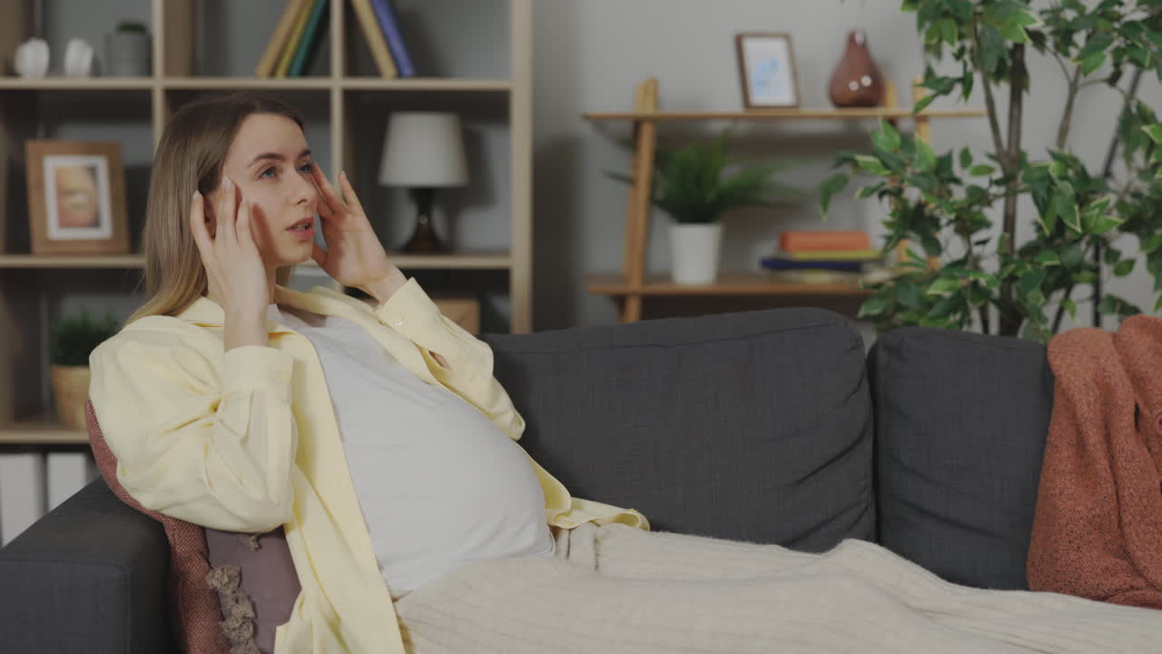 임신 중인 여성이 두통을 겪고 있습니다.