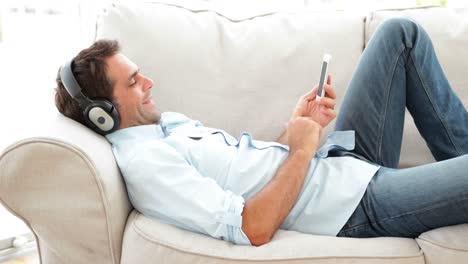 man lying on the couch listening to music