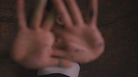 close-up of abstract painter showing her hands full of paint