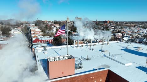 Fumes-of-chimney-on-roof-of-building-with-american-flag