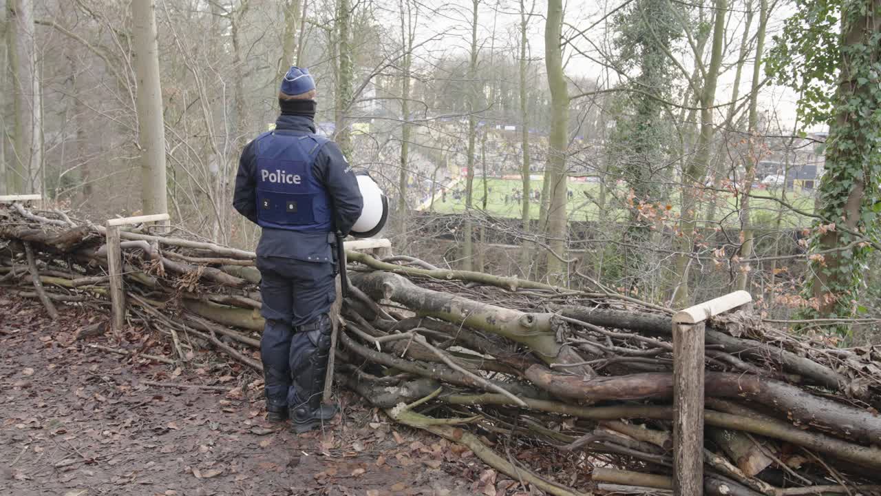 Police officer in the park patrolling soccer hooligans during mach between Royale Saint-Gilloise and Anderlecht