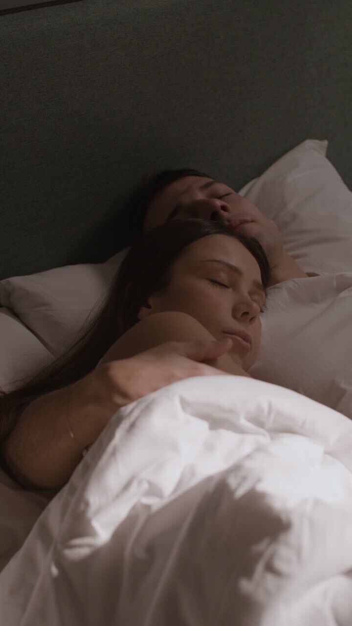 Una pareja durmiendo en la cama