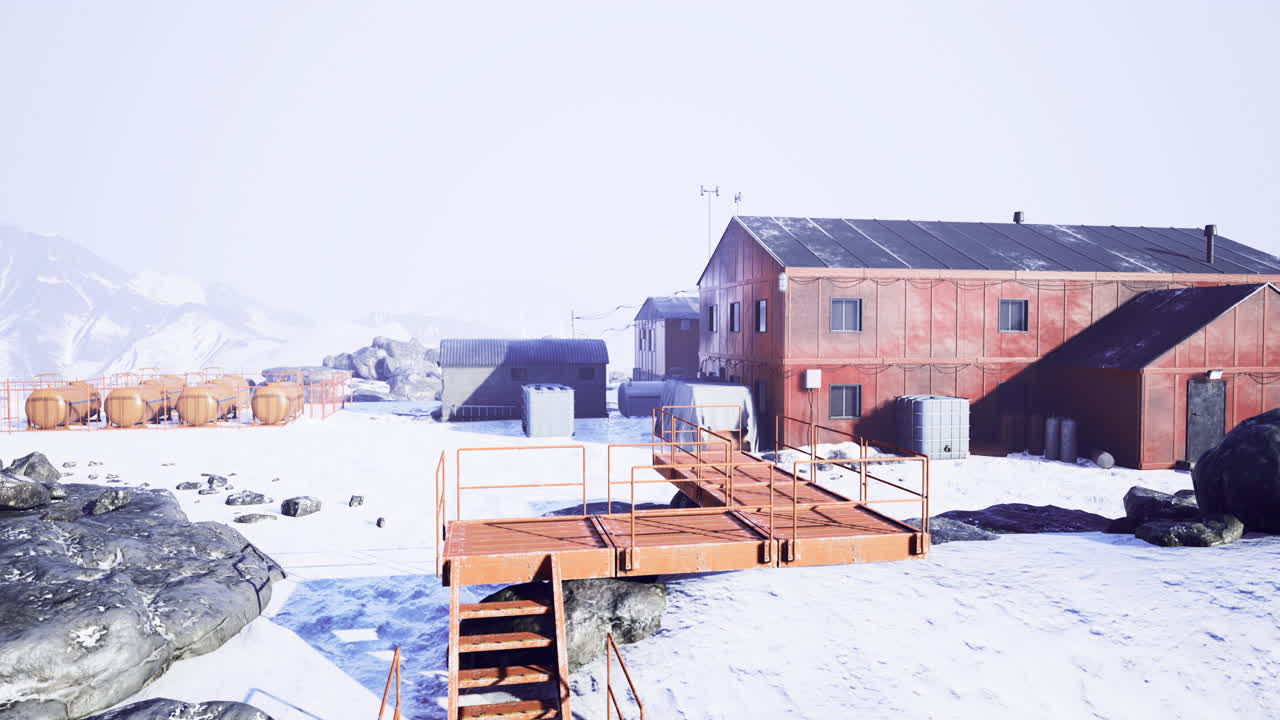 estación de investigación en un remoto paisaje nevado rodeado de montañas y hielo